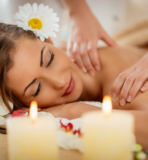 Beautiful woman enjoying during a shoulder massage at a spa.