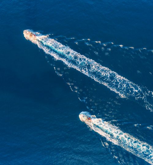 Yacht at the sea. Aerial view of luxury floating ship at sunset. Colorful landscape with boat in marina bay, blue sea. Top view from drone of yacht. Luxury cruise. Seascape with motorboat. Ocean