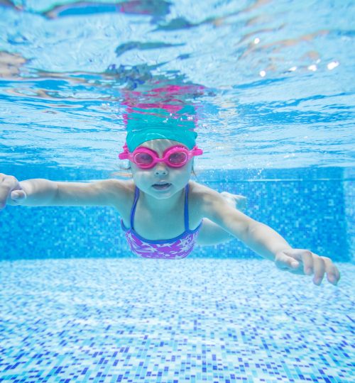 Cute little girl diving in swimming pool